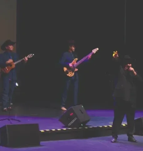  Concierto en el Teatro Colsubsidio con músicos en sombreros vaqueros tocando guitarra y bajo