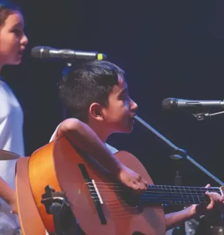 Niños en el Teatro Colsubsidio interpretan tambores y campanas.