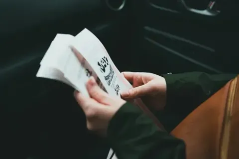 Manos en un vehículo revisando bonos de transporte Cabify.
