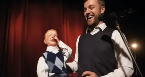 Ventrílocuo en el Teatro Colsubsidio con muñeco en escena.