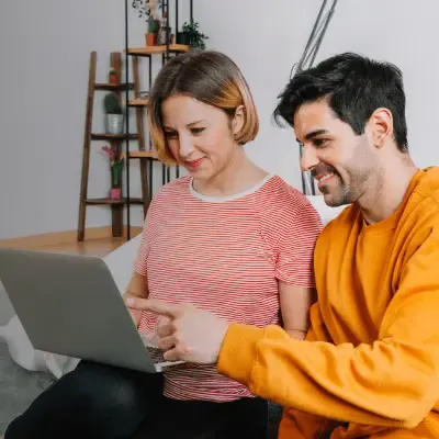 Una pareja revisando los términos y condiciones de bonos regalo en su laptop.