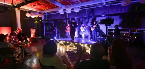  Concierto íntimo en Café de las Letras con cantantes y músicos en escena iluminada.