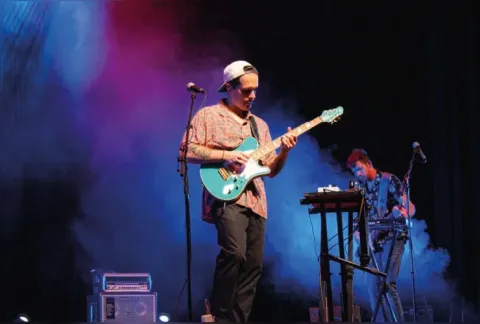 Dos músicos interpretan guitarra eléctrica y teclado en el Teatro Colsubsidio.