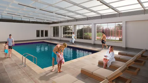 Piscina cubierta Panoramik, muestra una familia en la piscina bajo techo con vista al parque.
