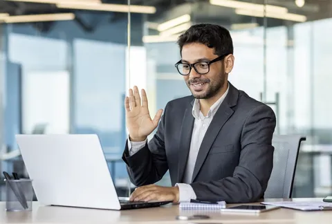 Empresario en una videollamada frente a su computador, beneficio Seguimiento Post-conexión.