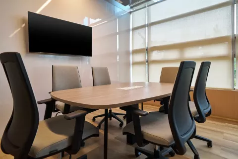 Una sala de reuniones con mesa en forma de U ovalada con TV para hasta 6 personas en Táctica BLOC Fontanar Colsubsidio