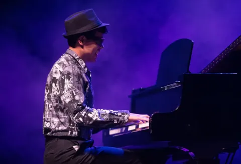 Hombre tocando el piano en el escenario del Teatro Colsubsidio.