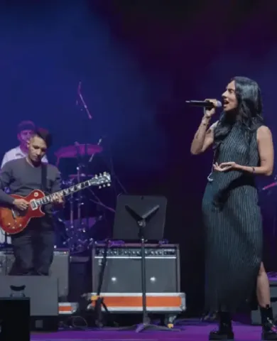 Cantante interpretando en el escenario junto a un guitarrista en una presentación de jazz.