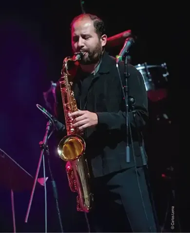 Saxofonista interpretando concentrado un solo en el escenario.