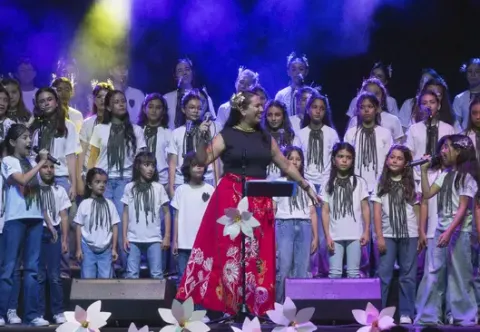 Marta Gómez cantando en el escenario junto al coro infantil Cantoalegre.