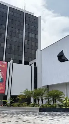 Fachada moderna del Teatro Colsubsidio con edificio acristalado y jardín exterior.