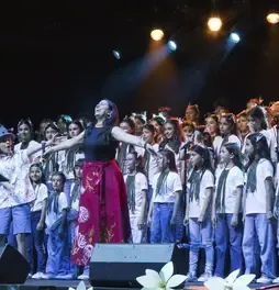 Marta Gómez abriendo los brazos en el escenario rodeada por los niños del coro Cantoalegre.Marta Gómez abriendo los brazos en el escenario rodeada por los niños del coro Cantoalegre.