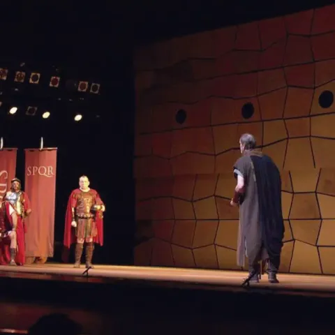  Actores con vestuario romano y banderas SPQR en una representación teatral.