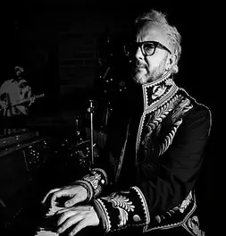 César López tocando el piano en una fotografía artística en blanco y negro.