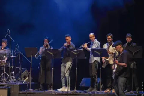 Agrupación musical de jazz interpretando en conjunto sobre el escenario.